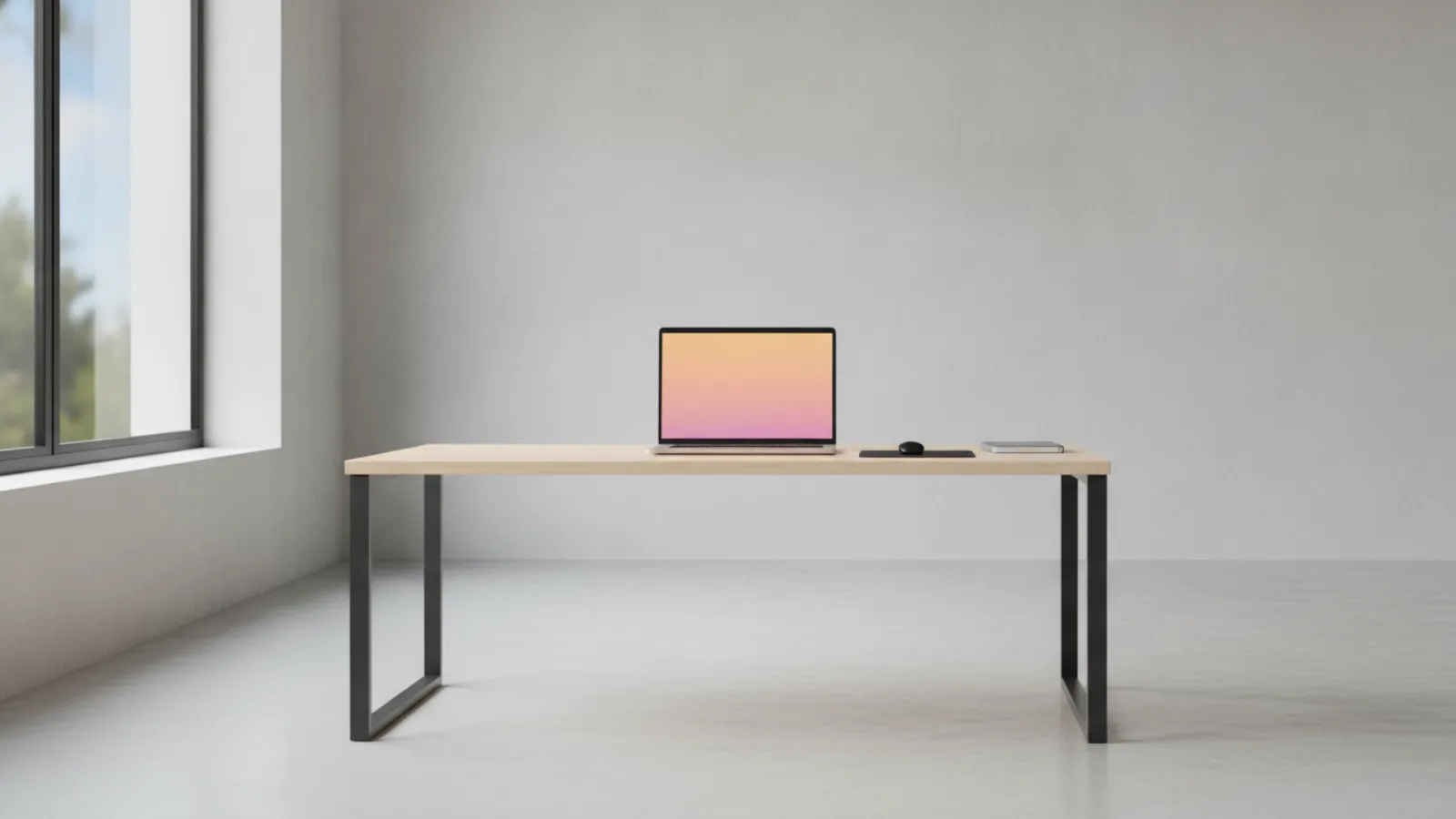 Laptop on a desk with its screen showing a soft orange and pink gradient glow